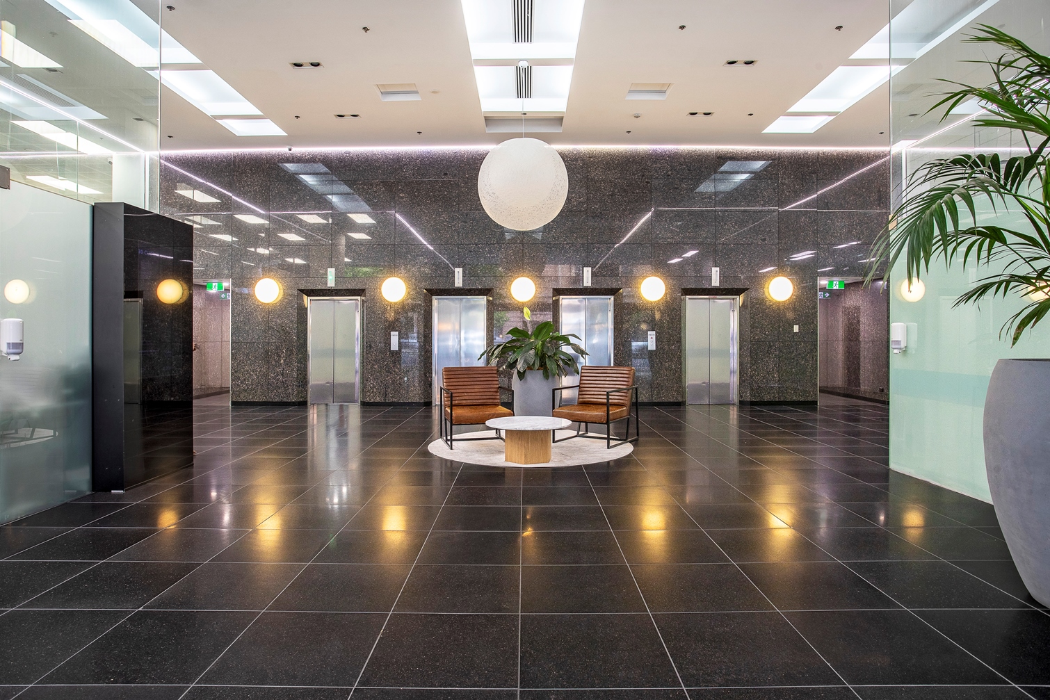 Foyer of 30 Currie Street, with waiting area and elevators in the space.