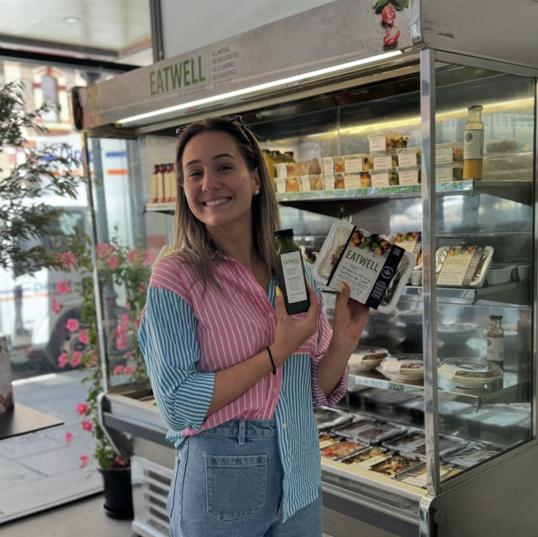 Woman holding up juice and pre-made meal