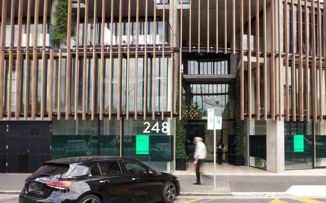 Street view of 246-248 Flinders St, a man walking past the property and on-street parking out the front of the premises.