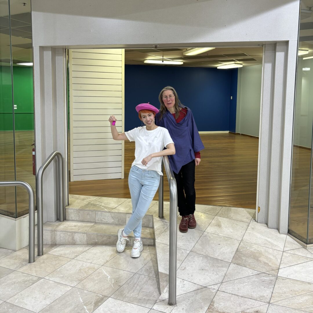Owners standing out the front of their space, Onnie wearing a white t-shirt, beret and jeans.