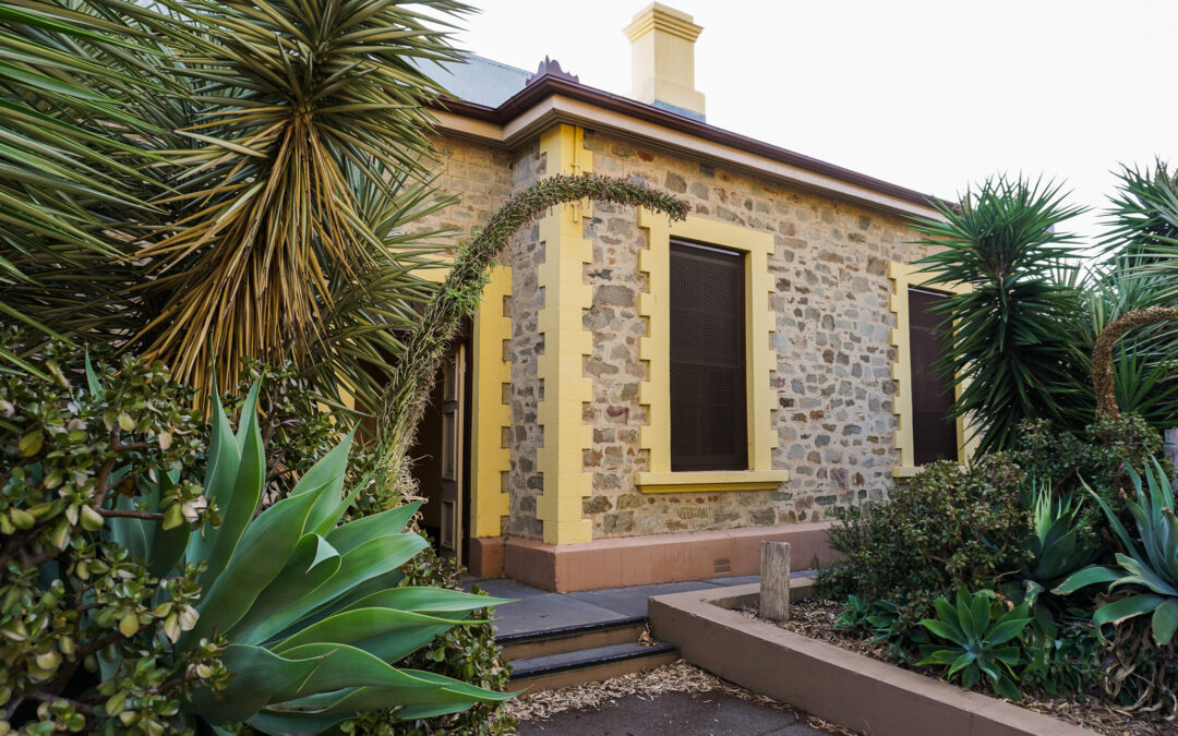 Exterior of North Adelaide Railway Station, showing stonework, yellow painted door frames and lots of succulents.