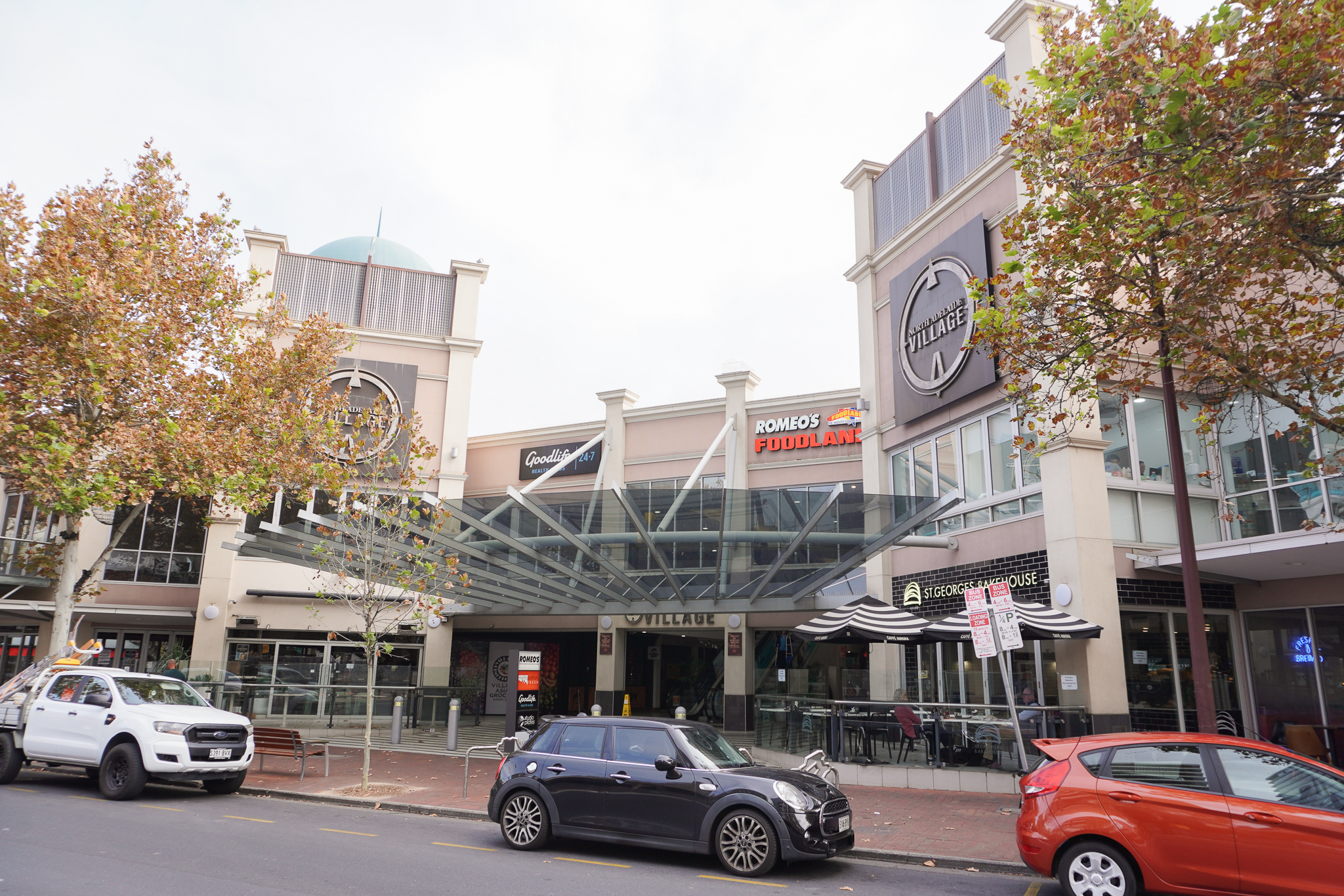 nav-exterior View of the shopping centre from O'Connell Street, showing parked cars, street and leafy trees.