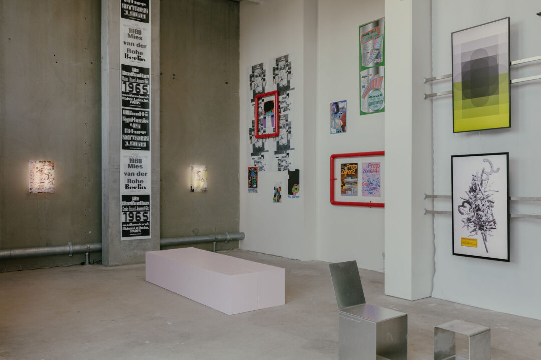 Industrial space with concrete walls and floors and graphic designed artwork on the walls.