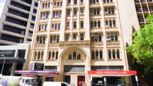 Exterior of Epworth Building, with Gothic style architecture and eateries on the ground level.