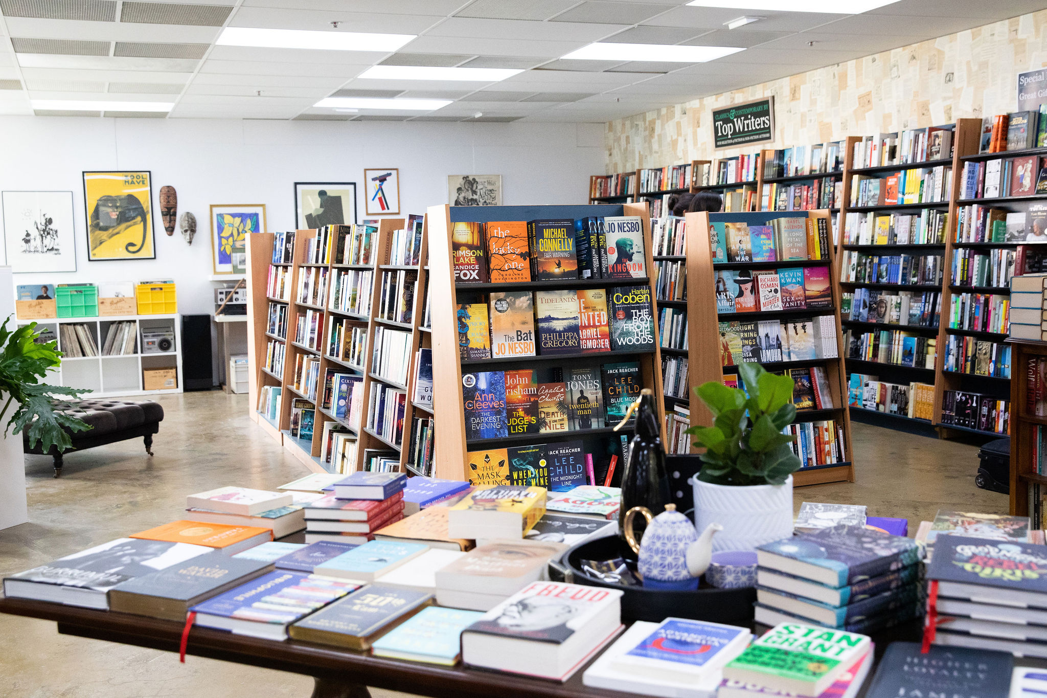 Bookshop with book display in foreground and shelves full of books in background.